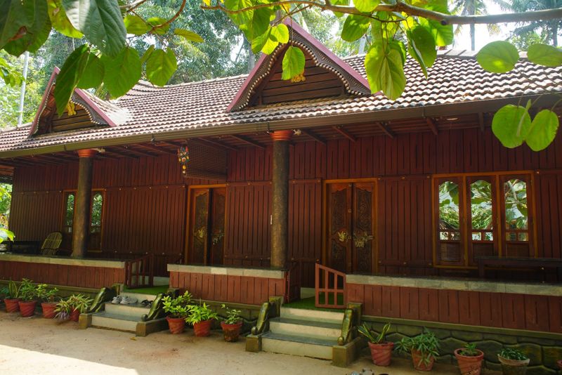 The traditional Kerala-style wooden house at Munroe Meadows, with its garden